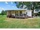 Backyard featuring a covered deck that flows to green grass and a garden area at 805 Caldwell St, Belmont, NC 28012