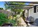 Relaxing backyard retreat, featuring a pergola, lush plants, and a stone pathway along the house at 805 Caldwell St, Belmont, NC 28012