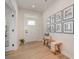 Bright entryway features light wood floors, a stylish bench, and an elegant gallery wall for a welcoming atmosphere at 808 Dogwood Creek Ln, Indian Trail, NC 28079