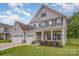 Charming two-story home with gray siding, black shutters, a three-car garage, and a well-manicured lawn at 808 Dogwood Creek Ln, Indian Trail, NC 28079