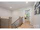 Upstairs hallway with wood and black iron banister leading to a bedroom at 808 Dogwood Creek Ln, Indian Trail, NC 28079