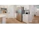 Bright kitchen showcasing stainless steel refrigerator, white cabinets, and sleek countertops, offering modern functionality at 808 Dogwood Creek Ln, Indian Trail, NC 28079