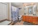 A bathroom with a wood vanity, and a shower with a blue patterned curtain at 8119 Tremaine Ct # E, Charlotte, NC 28227