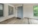 A welcoming entrance with a gray front door and windows to either side with a wooden porch at 8119 Tremaine Ct # E, Charlotte, NC 28227