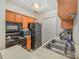 A kitchen with black appliances and wooden cabinets including a double basin sink at 8119 Tremaine Ct # E, Charlotte, NC 28227