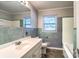 Retro bathroom with green tile, a sleek white vanity, and a well-lit mirror, blending vintage charm with functionality at 828 Williams St, Gastonia, NC 28052