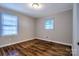 Serene bedroom with gleaming hardwood floors, neutral walls, and ample natural light streaming through two windows at 828 Williams St, Gastonia, NC 28052