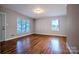 Open living room with gleaming hardwood floors, neutral paint, and multiple windows offering abundant natural light at 828 Williams St, Gastonia, NC 28052