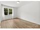 Bright, empty bedroom with neutral walls, light wood floors, and a large window at 8438 Henry Harris Rd, Fort Mill, SC 29707