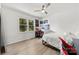Bedroom featuring a large window, fan, desk with chair and lightly stained floors at 8438 Henry Harris Rd, Fort Mill, SC 29707