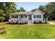 Charming single-story home featuring light blue siding, a welcoming front porch, and beautifully landscaped front yard at 8438 Henry Harris Rd, Fort Mill, SC 29707