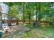 Private backyard featuring a brick patio, mature trees, and a wooden fence at 8701 Appaloosa Way Ln, Charlotte, NC 28216