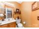 Half bathroom with decorative wallpaper, vanity and commode at 8701 Appaloosa Way Ln, Charlotte, NC 28216