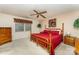 Spacious bedroom with a red comforter on a wooden bed frame and ceiling fan at 8701 Appaloosa Way Ln, Charlotte, NC 28216