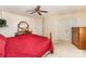 Bedroom features a red comforter, wooden bed frame and ceiling fan at 8701 Appaloosa Way Ln, Charlotte, NC 28216
