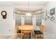 Charming dining nook with a round wood table, bay window, and decorative valance at 8701 Appaloosa Way Ln, Charlotte, NC 28216