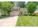 Charming two-story home featuring a well-manicured lawn, mature trees, and a two-car garage at 8701 Appaloosa Way Ln, Charlotte, NC 28216