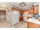 Traditional kitchen with oak cabinets, white appliances, and neutral backsplash at 8701 Appaloosa Way Ln, Charlotte, NC 28216