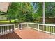 A wood deck with white and black railings overlooks the backyard with lush green grass at 10514 Harbor Dr, Charlotte, NC 28214