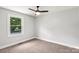 Bedroom showcasing neutral tones, plush carpet, and a large window with views of nature, creating a serene retreat at 10514 Harbor Dr, Charlotte, NC 28214