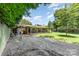 Spacious backyard with a home featuring a covered patio, bordered by a fence and trees at 107 Skyuka Rd, Statesville, NC 28677