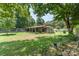 Backyard view of a home with a covered patio, nestled among mature trees and greenery at 107 Skyuka Rd, Statesville, NC 28677