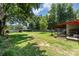 Lush backyard with mature trees, featuring a home with a covered patio at 107 Skyuka Rd, Statesville, NC 28677