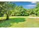 Spacious backyard with lush green grass, mature trees and a patio area perfect for outdoor living at 113 Lou Dr, Gastonia, NC 28052