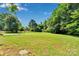 Picture of an expansive backyard with lush green grass and mature trees in a serene setting at 113 Lou Dr, Gastonia, NC 28052