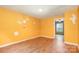 Bedroom features yellow walls, wood floors, views to another room, and a window for natural light at 1145 Earl Rd, Shelby, NC 28152