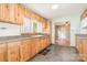 This kitchen has warm wood cabinetry, tile floors, a sunny window, and views to other rooms at 1145 Earl Rd, Shelby, NC 28152