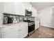 Kitchen features white cabinets, subway tile backsplash, and stainless steel appliances at 125 White Apple Way, Statesville, NC 28625