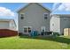 A backyard features a grassy lawn, a seating area, a grill, and a view of the home's gray siding at 12522 Palomino Dr, Midland, NC 28107