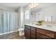 Bathroom featuring double vanity, wood-look floors, shower with curtains, and natural light at 12522 Palomino Dr, Midland, NC 28107