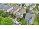 Aerial view of a neighborhood with yellow two-story house, mature trees, and well-manicured lawns enhancing curb appeal at 12525 Druids Glen Dr, Pineville, NC 28134