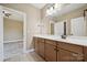 Spacious bathroom with wood vanity, and a large mirror, perfect for a Gathering or anyone needing extra space at 12525 Druids Glen Dr, Pineville, NC 28134