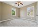 Bright bedroom featuring neutral paint, plush carpet, a ceiling fan, and natural light creating a serene atmosphere at 12525 Druids Glen Dr, Pineville, NC 28134