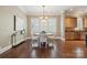 Bright dining area with large windows, a chandelier, and seamless access to the adjacent kitchen at 12525 Druids Glen Dr, Pineville, NC 28134