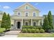 Charming two-story home with a welcoming front porch, manicured landscaping, and lush greenery at 12525 Druids Glen Dr, Pineville, NC 28134