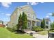 Charming two-story home featuring a welcoming front porch, lush green lawn, and mature trees at 12525 Druids Glen Dr, Pineville, NC 28134