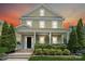 Charming two-story home with a welcoming front porch, manicured landscaping, and lush greenery at 12525 Druids Glen Dr, Pineville, NC 28134