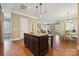 Open concept kitchen with a dark wood kitchen island, bar stool seating, and hardwood flooring at 12525 Druids Glen Dr, Pineville, NC 28134