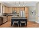 Spacious kitchen with wood cabinets, granite countertops, stainless steel appliances, island, and barstool seating at 12525 Druids Glen Dr, Pineville, NC 28134