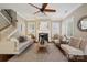 Inviting living room with a cozy fireplace, neutral tones, and a ceiling fan for added comfort at 12525 Druids Glen Dr, Pineville, NC 28134