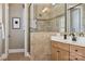 Main bathroom with double sink vanity, framed mirrors, a glass-enclosed shower, and tile flooring at 12525 Druids Glen Dr, Pineville, NC 28134