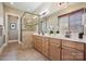 Main bathroom with double sink vanity, framed mirrors, a glass-enclosed shower, and tile flooring at 12525 Druids Glen Dr, Pineville, NC 28134