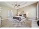 Large main bedroom with tray ceiling, ceiling fan, carpet, and lots of natural light from the windows at 12525 Druids Glen Dr, Pineville, NC 28134