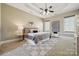 Large main bedroom with tray ceiling, ceiling fan, carpet, and lots of natural light from the windows at 12525 Druids Glen Dr, Pineville, NC 28134