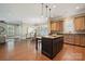 Open-concept kitchen, dining and living space with stainless appliances, breakfast bar and ample natural light at 12525 Druids Glen Dr, Pineville, NC 28134