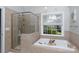 Well-lit bathroom showcases a tiled shower and soaking tub with a window view at 1587 Summit View Dr, Rock Hill, SC 29732